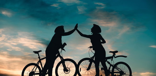 zwei Radfahrer begrüßen sich